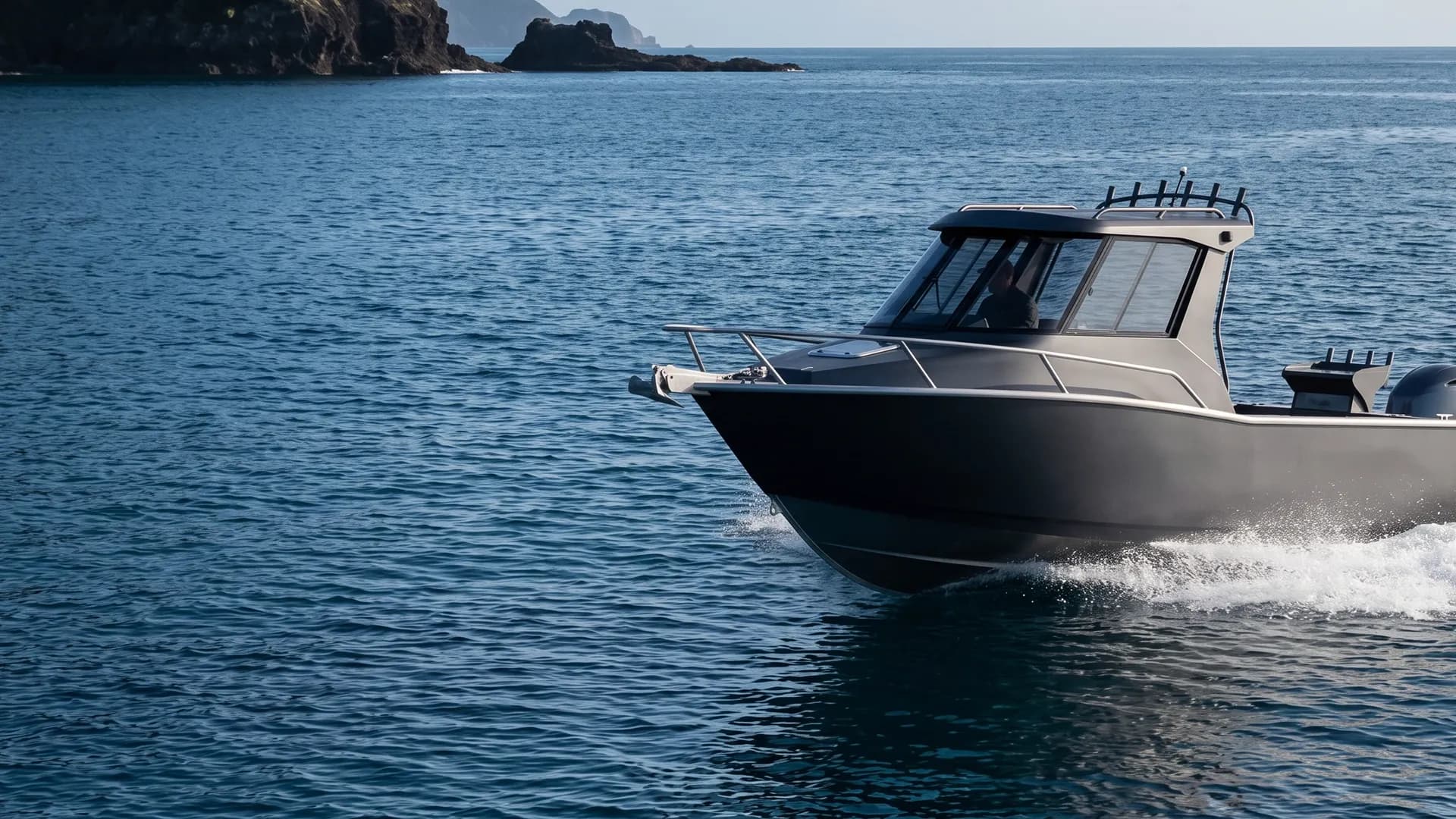 Grey vinyl wrapped boat planing on blue ocean