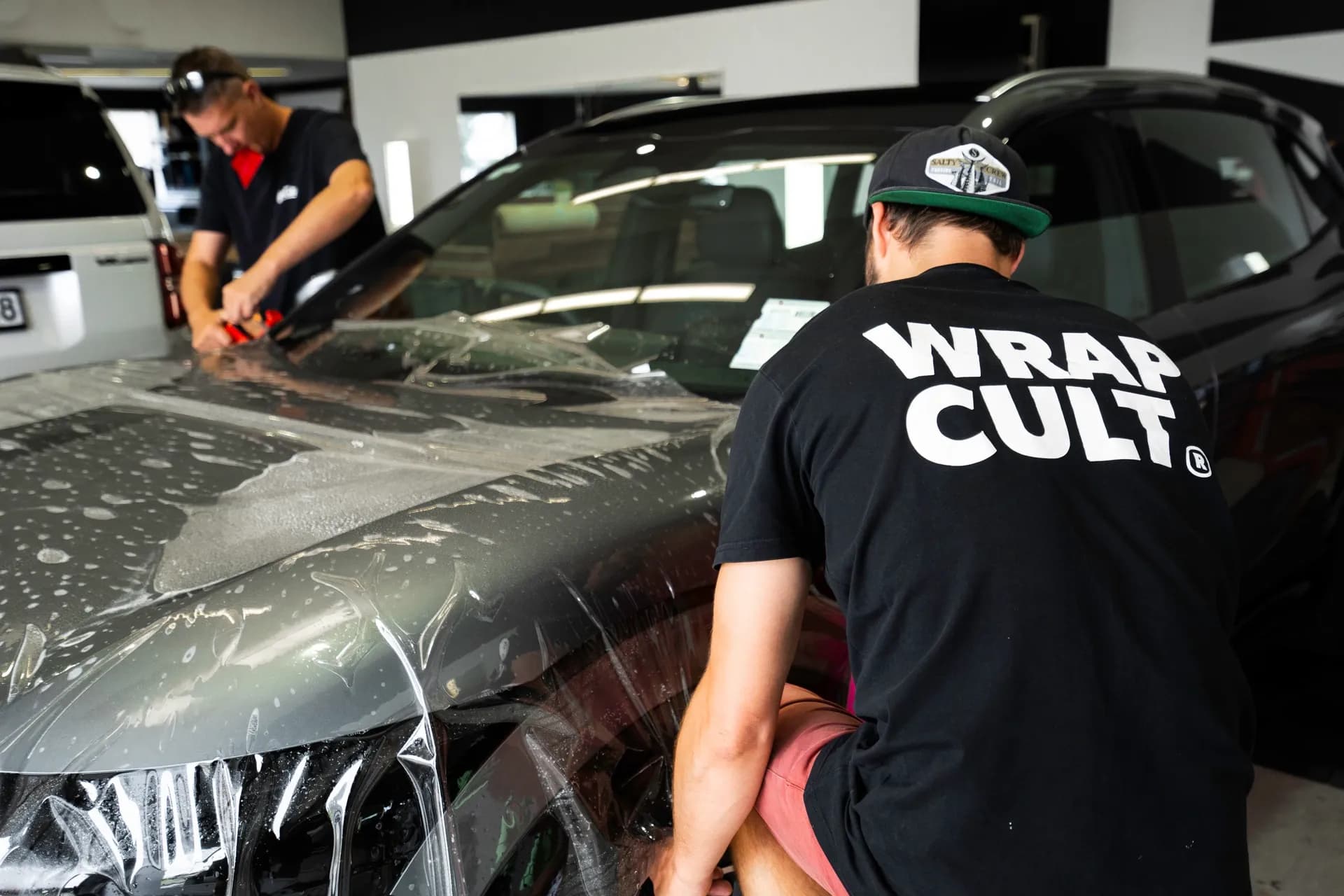 Wrap Culture technicians applying paint protection film to a vehicle bonnet