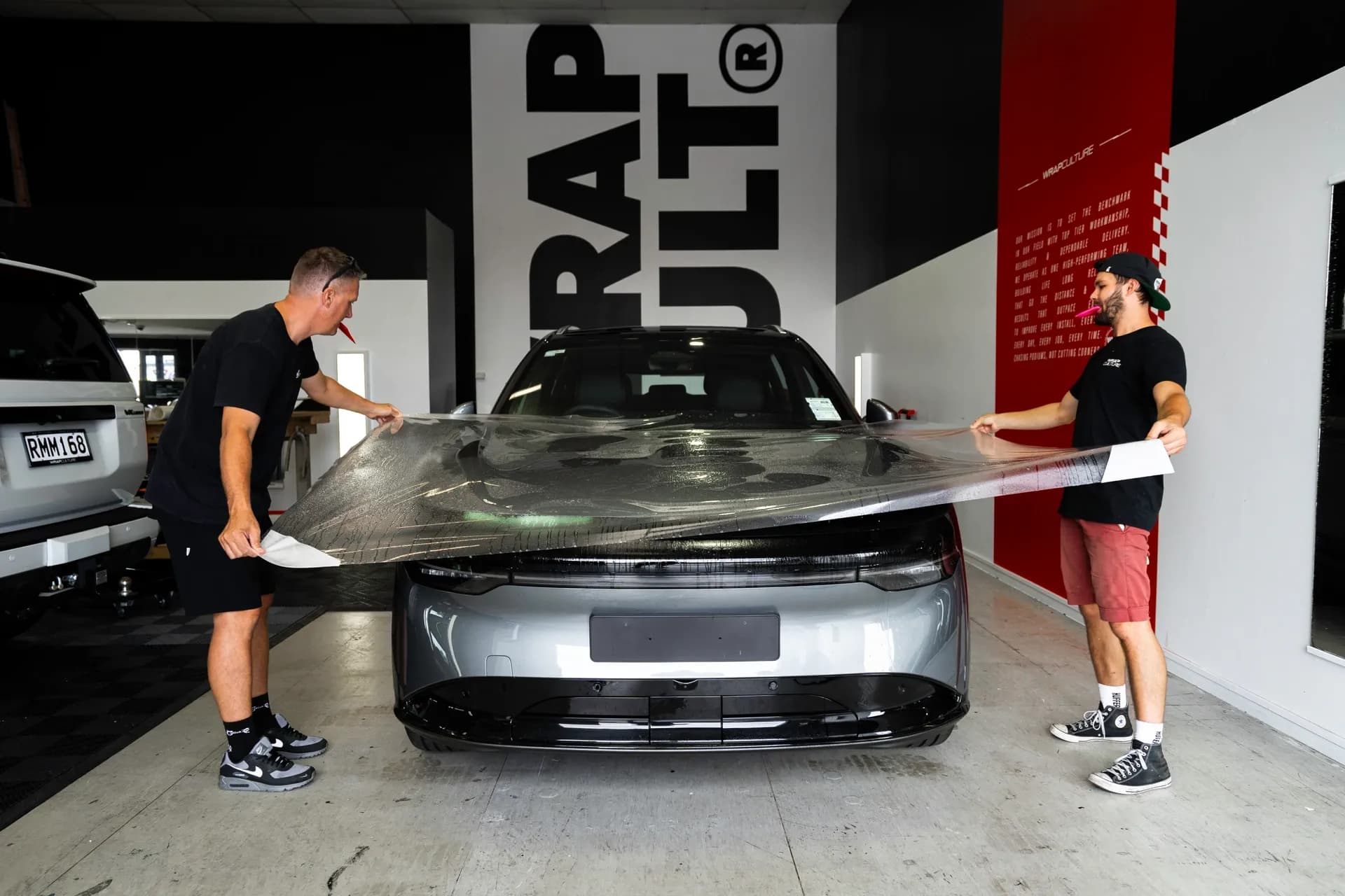 Wrap Culture team applying paint protection film to a vehicle in the Mount Maunganui workshop
