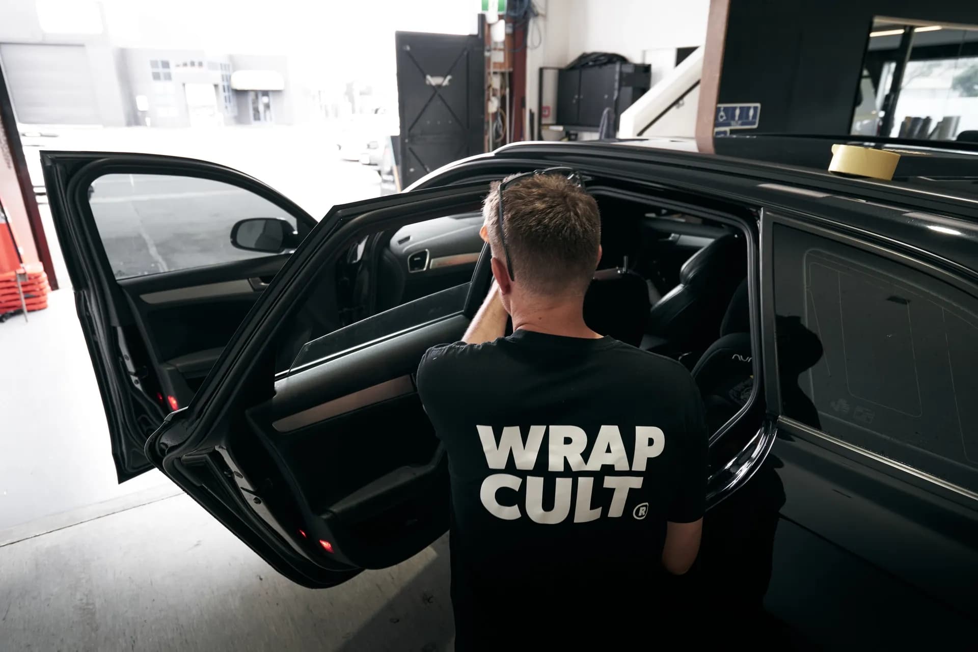 Wrap Culture technician getting into a wrapped vehicle in the workshop